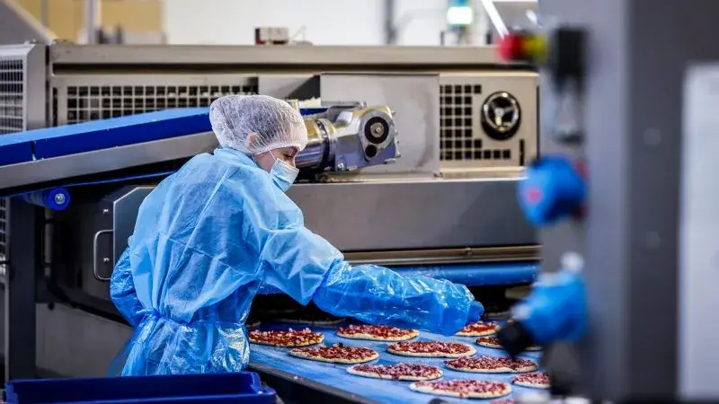 Personnes travaillant sur une chaine de production de nourriture