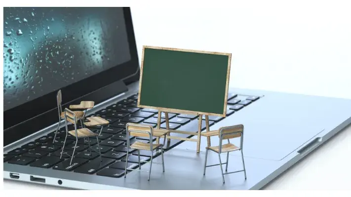 Un tableau d'école et des chaises posés sur un ordinateur