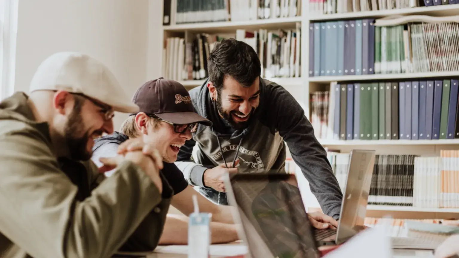 Hommes en train de rire devant un ordinateur