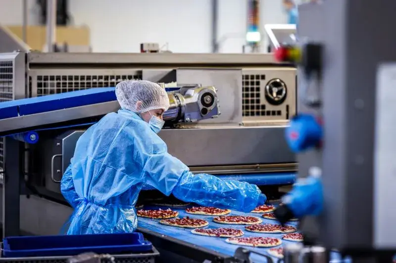 Personnes travaillant sur une chaine de production de nourriture