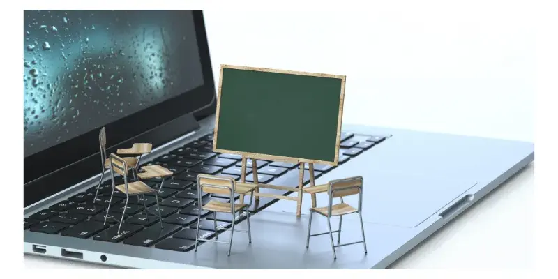 Un tableau d'école et des chaises posés sur un ordinateur