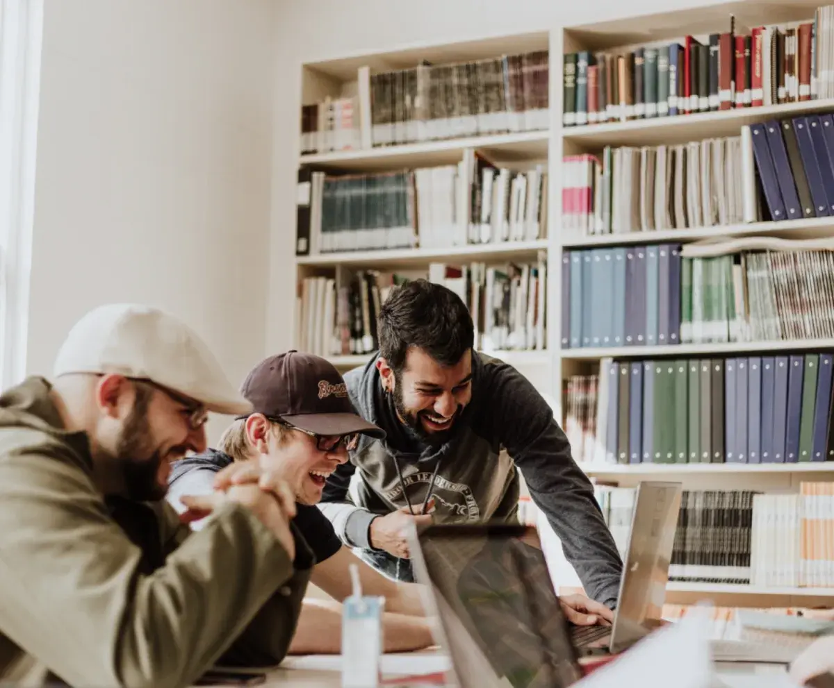 Hommes en train de rire devant un ordinateur